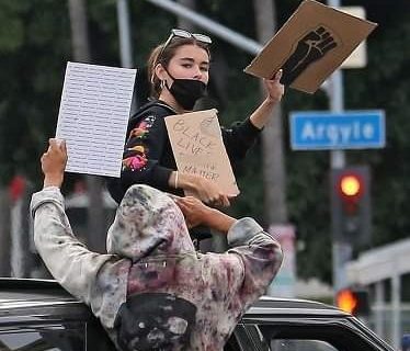 حلو الفن - ماديسون بير تتظاهر "على سقف" إحدى السيارات مطالبة بـ "المساواة".. صور